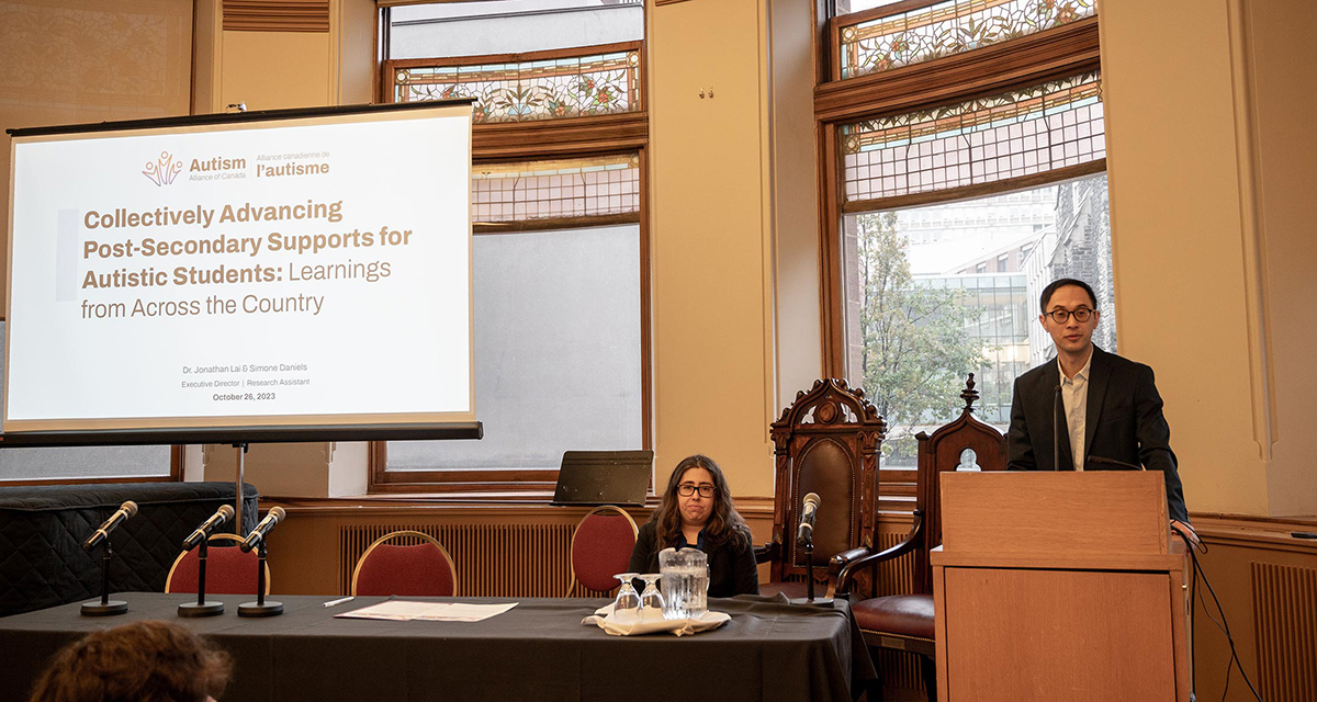 (L-R) Simone Daniels and Jonathan Lai engage the audience at Minding Our Minds. Lai stands confidently at the podium, delivering a compelling address.